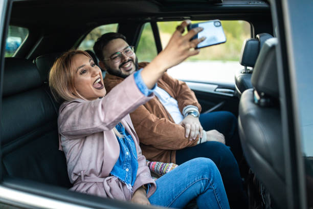 istock Cheerful friends having fun on back seat in a car 1158819983