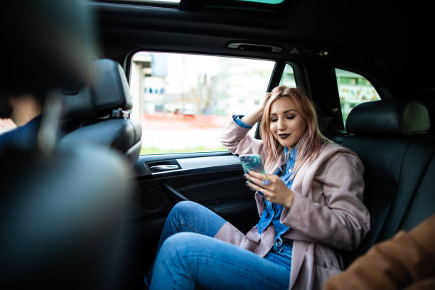 Woman driving on back seat and using smart phone