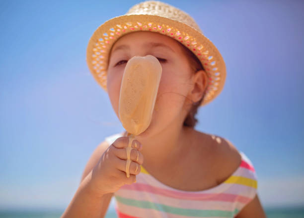 istock Cute child on the beach eating a melting ice cream 1158820697