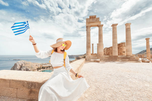 Woman Traveler with backpack Enjoying great view og the ancient Greek Acropolis with flag in hands Woman Traveler with backpack Enjoying great view og the ancient Greek Acropolis with flag in hands acropolis athens photos stock pictures, royalty-free photos & images