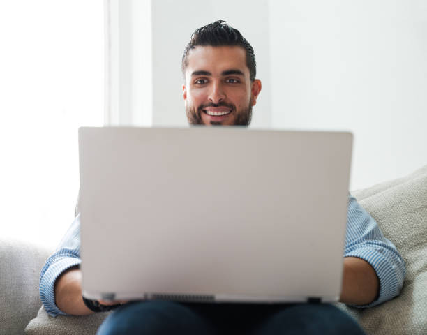 istock Modern man with laptop sitting at home 1158821975