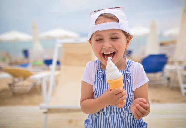 istock Cute smiling child eating a vanilla ice cream cone 1158823510