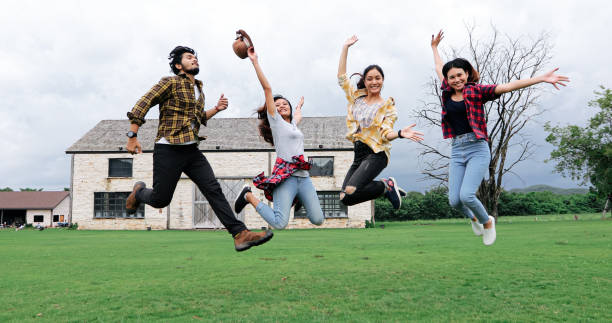 istock Successful Young students at campus looking at camera and smiling and high five while jumping on outdoors. 1158824201