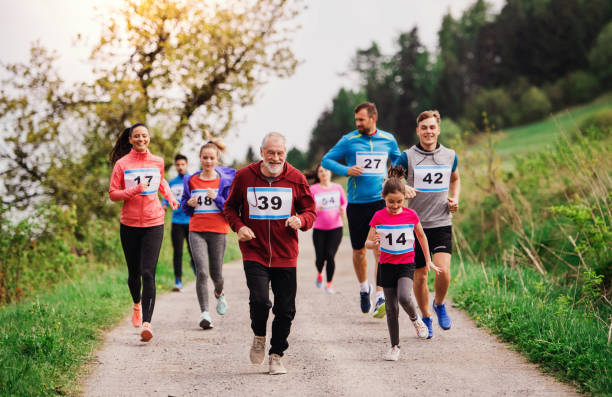 istock Large group of multi generation people running a race competition in nature. 1158824328