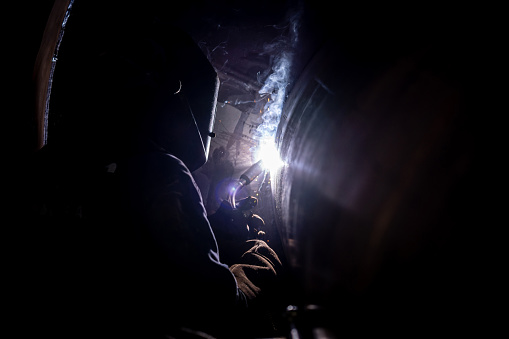Close-up on a welder welding at a metallurgic factory - industry concepts