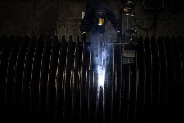 Latin American welder working at a factory and wearing protective wear â industrial concepts