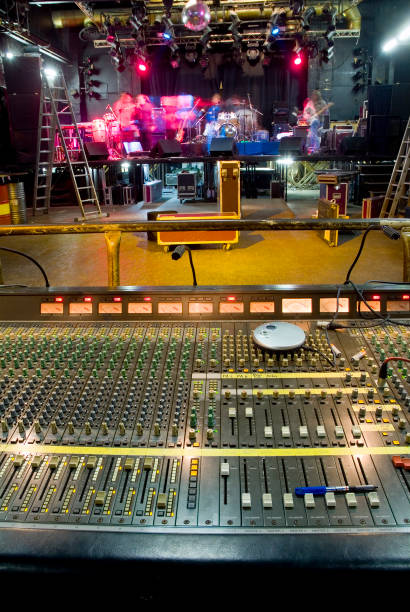 istock Front of house soundboard with band setting up on stage 115883044