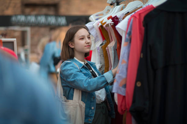 istock Young girl choosing clothes in a second hand market in summer, zero waste concept 1158833308