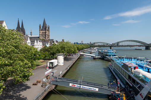 Cologne, Germany - June 25 2019: Large passenger ferries docked on the River Rhine in Cologne, in the city centre. Cathedral is seen in the background.