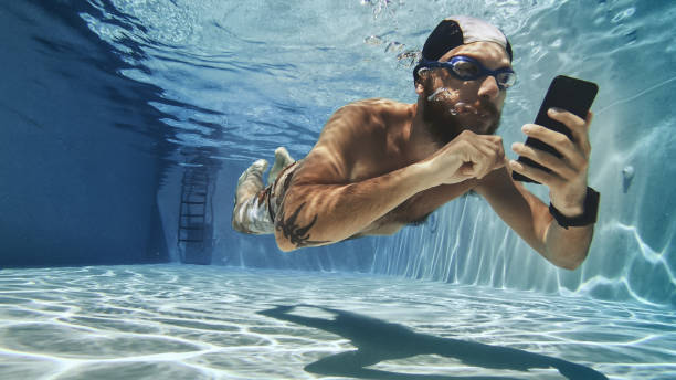 Workaholic man using mobile phone underwater stock photo