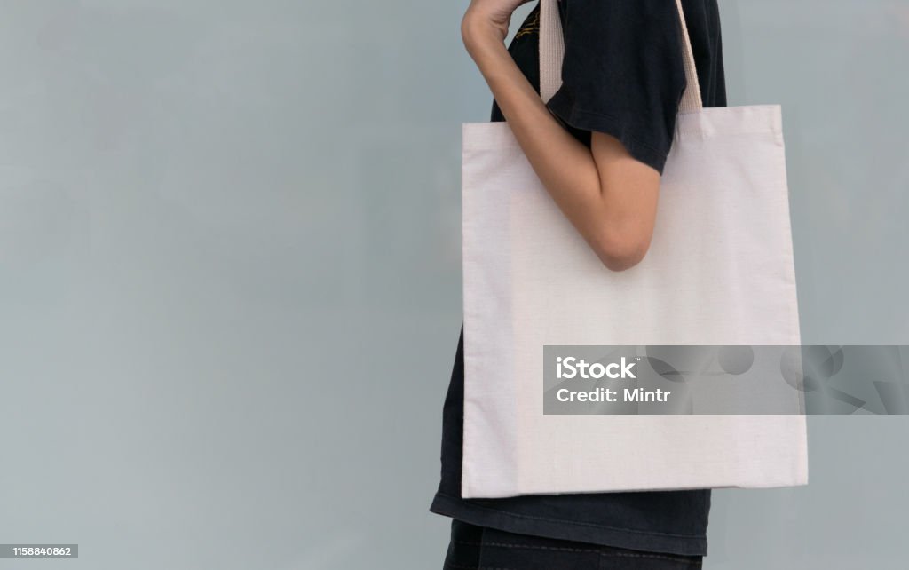 woman carry bag on nature background in save earth concept or say no plastic bag. Tote Bag Stock Photo
