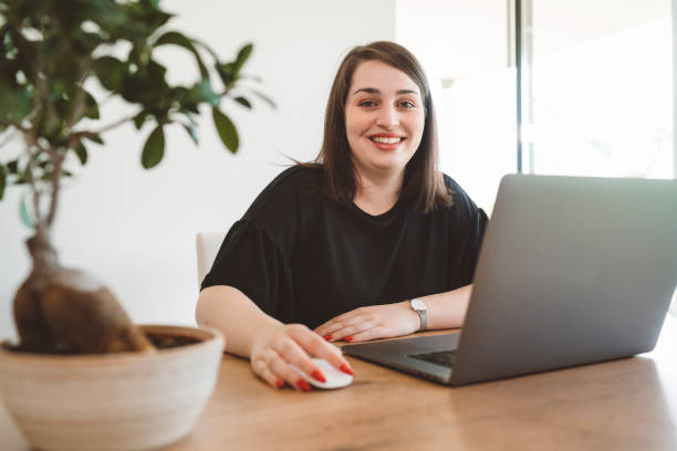 istock Woman with a smile on her face working on her computer 1158844789