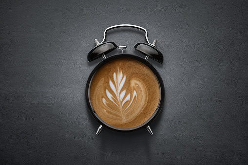 Coffee clock on dark concrete background with copy space