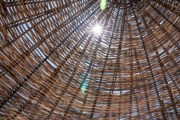 Summer vibe concept. In a sunny day, light rays of sun pass through from straw beach umbrella.