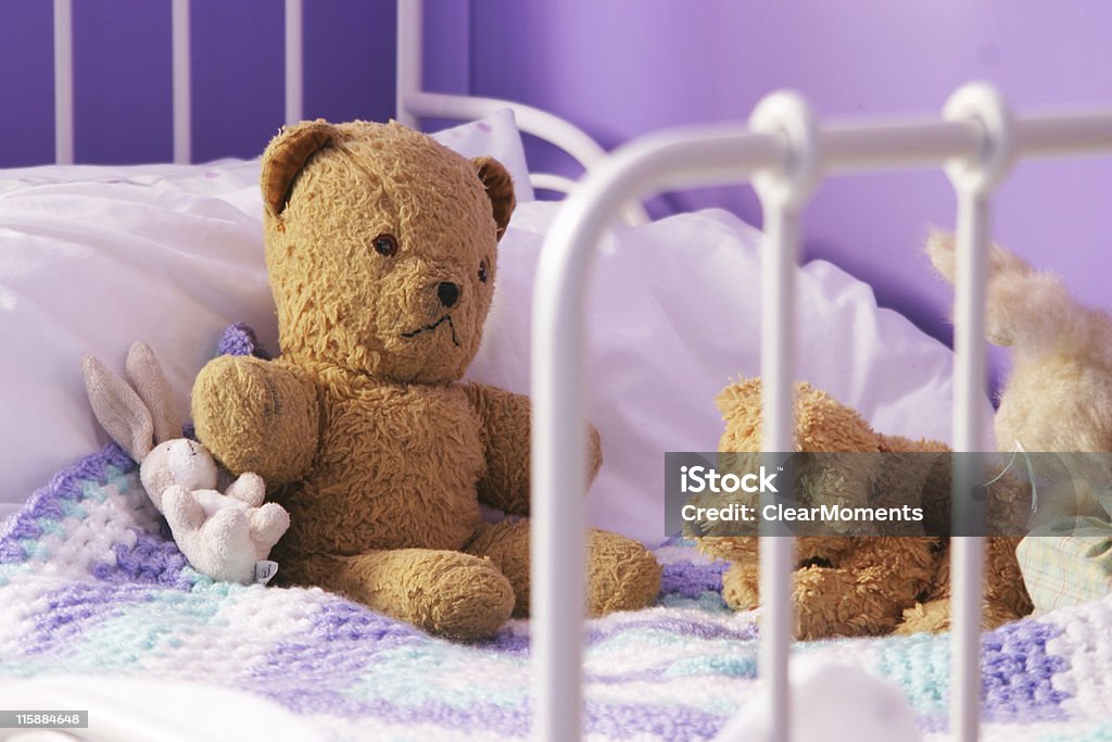 Scruffy old teddy bears on a child's bed Slightly dog-eared old (1960s) stuffed toys on a small child's bed Blanket Stock Photo