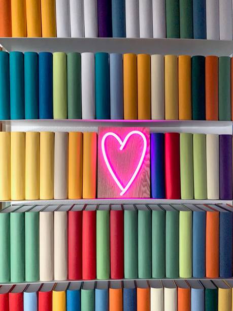 istock Books shelves packed with generic colorful books and a neon heart shape 1158847520