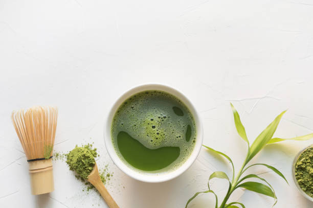 té matcha verde y batidor de bambú sobre mesa de hormigón blanco. vista superior. - té matcha fotografías e imágenes de stock