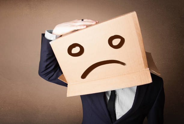 istock Businessman gesturing with cardboard box on his head with sad face 1158849361