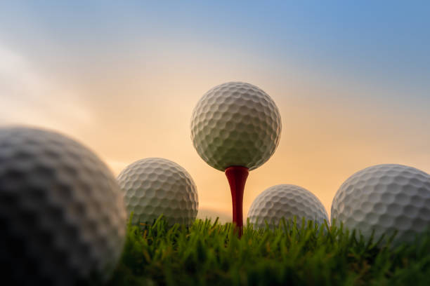 esporte ao ar livre, bola de golfe em tee pegs pronto para jogar na grama verde - golf golf swing sunset golf course - fotografias e filmes do acervo