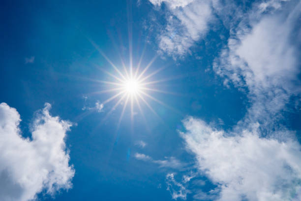 istock blue sky with clouds and sun shines bright in the day 1158849989
