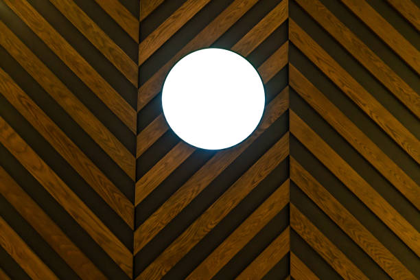 Blank round signboard hanging against wood pattern background. Interior design detail.