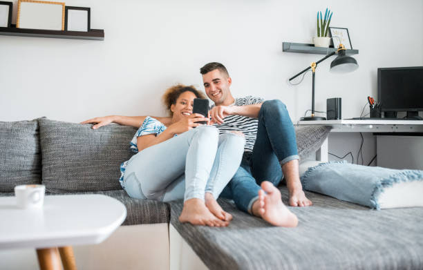 istock Heterosexual couple sitting on the sofa and using a smart phone 1158850246