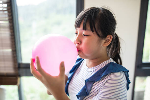 chica taiwanesa haciendo estallar globo - balloon blowing inflating child fotografías e imágenes de stock