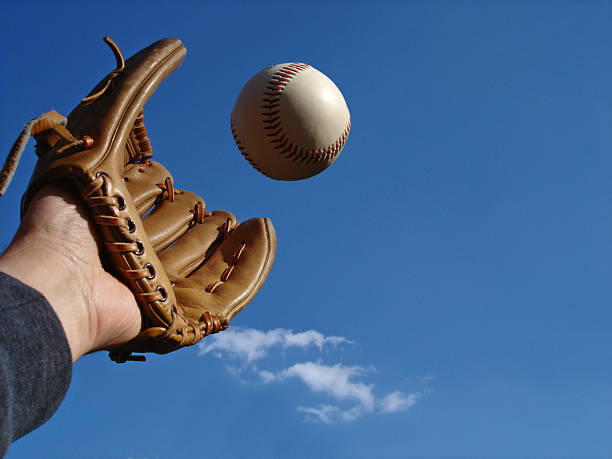 The Big Catch Catching a baseball against a blue sky. Right of photo offers negative space. outfield stock pictures, royalty-free photos & images