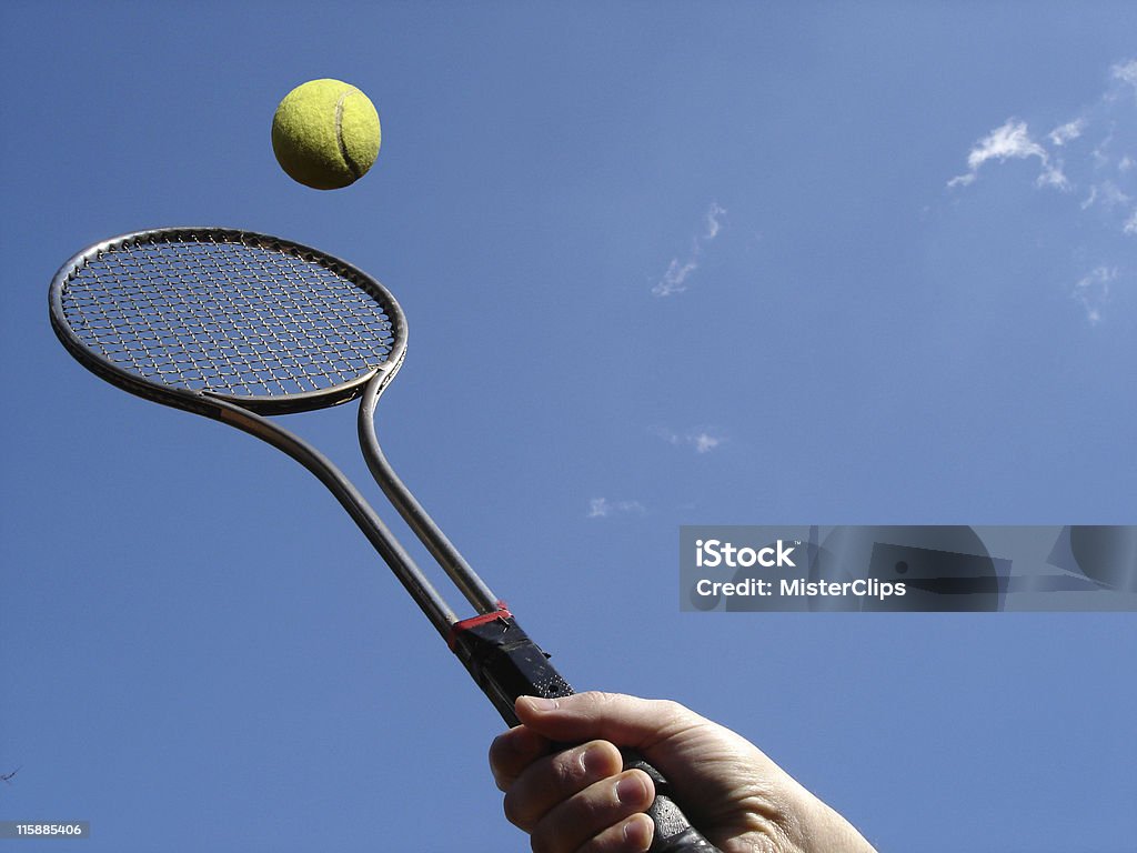 Tennis Return Tennis racket against blue sky right before returning the tennis ball to the opponent. Above Stock Photo