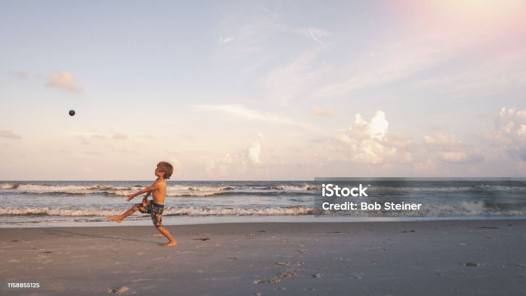 Beach Hacky Sack A young boy practices his soccer skills at the beach during sunset hours along Florida's gulf coast. Action Figure Stock Photo