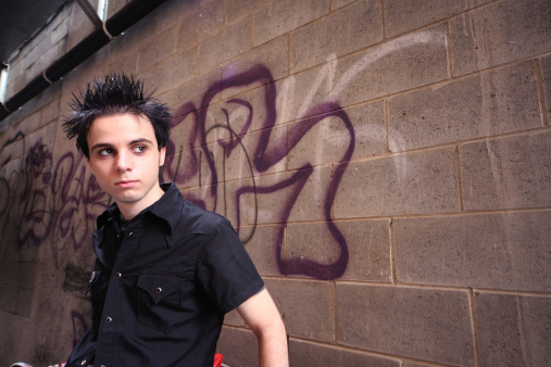 Young man in front of grunge wall.