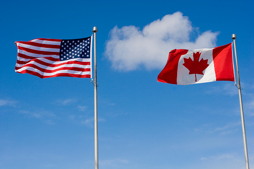 American and Canadian flags flying side by side