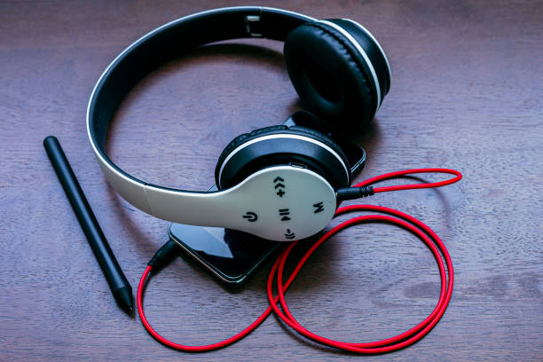 istock Black headphones on old wooden table 1158860473