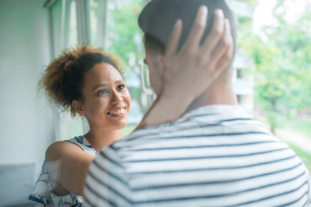 istock Young couple standing in the balcony and embracing each other 1158861505