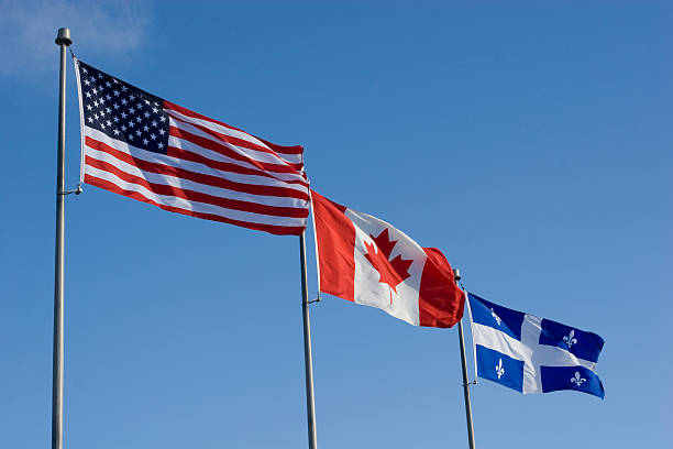 amerikanische, kanadische und quebec flaggen fliegen seite von si - canada american flag canadian culture usa stock-fotos und bilder