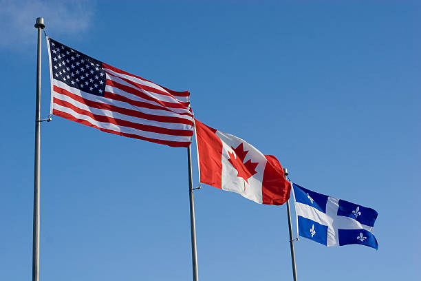 istock American, Canadian and Quebec Provincial flags flying side by si 115886308