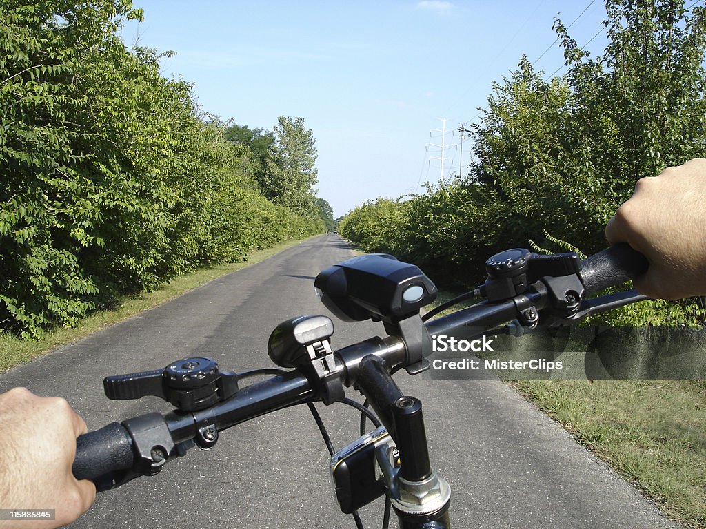 Summer Bike Ride A view from the handlebars during a summer bike ride down a bike path. Amusement Park Ride Stock Photo