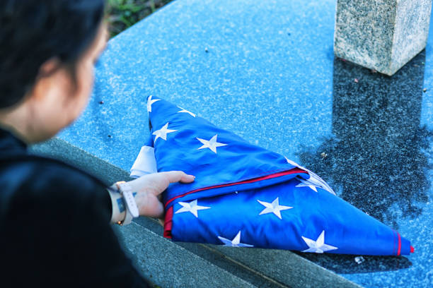 istock Young war widow lays a US flag on a gravestone 1158875227