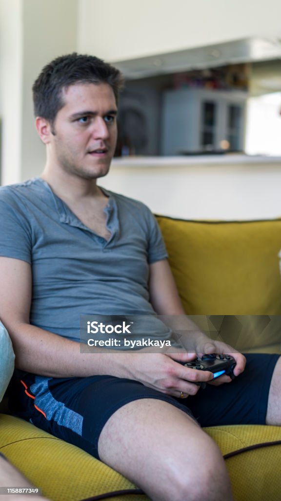 Two friends playing playstation Hand Stock Photo