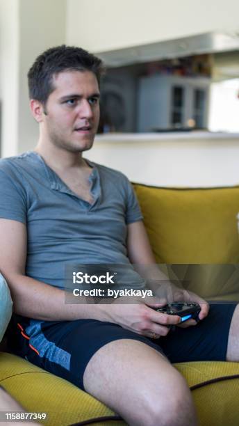 Two Friends Playing Playstation Stock Photo - Download Image Now - Hand, Video Game, Adult
