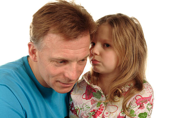 istock little girl whispering secrets to father 115887750
