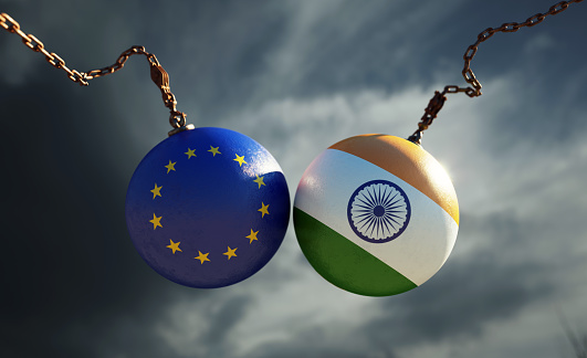 Wrecking balls textured with European Union and Indian flags over dark stormy sky. Horizontal composition with copy space and selective focus. Dispute concept.