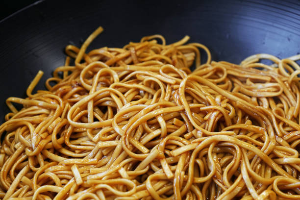 istock Close up Asian fried noodles in wok pan 1158887027