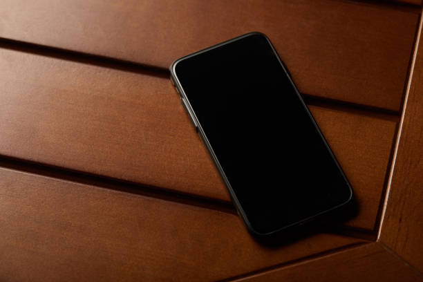 istock smartphone with blank screen and copy space on wooden table 1158888380