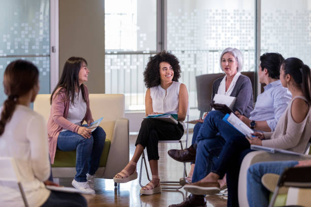 istock Diverse therapy group members look and listen while therapist speaks 1158889500