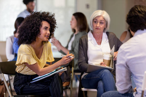 istock Mid adult assistant asks new employee question as boss watches 1158889655