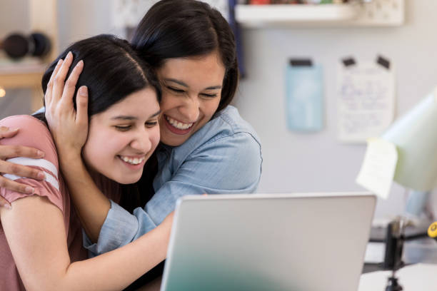 istock Mother and daughter hug to celebrate project completion 1158889697
