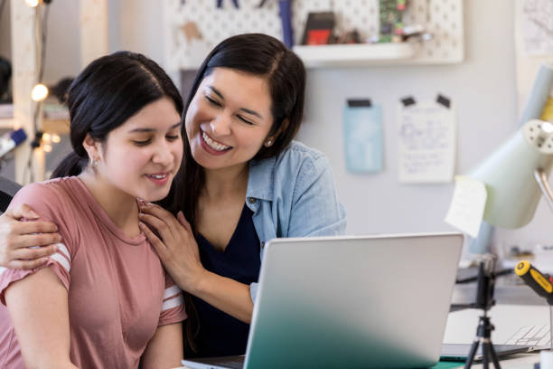 istock Mother hugs daughter after seeing her good work on laptop 1158889713