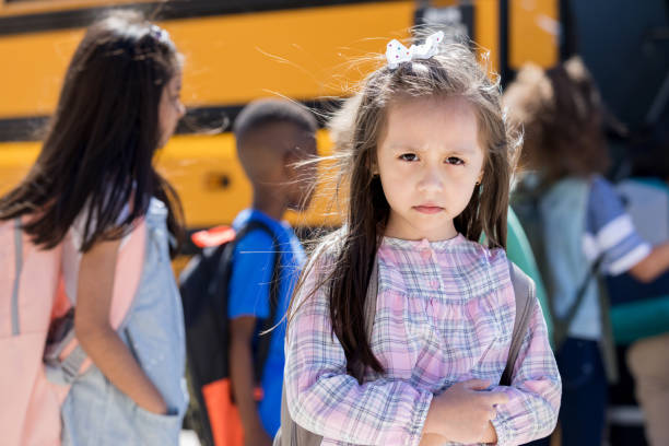 학교 버스 앞에 서있는 슬픈 어린 소녀 - back to school child first day of school school bus 뉴스 사진 이미지