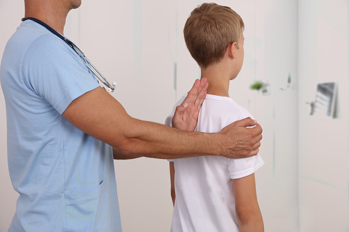 Niño con ajuste quiropráctico en la espalda. Osteopatía, Fisioterapia, Kinesiología. Corrección de mala postura photo